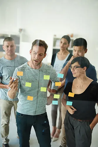Teilnehmende arbeiten in Gruppen an Design-Thinking-Übungen im Workshop